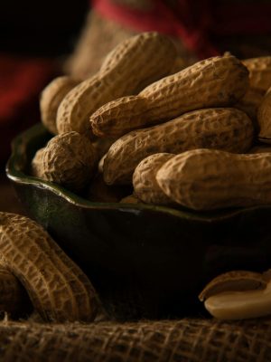 A bowl full of organic peanuts in their shells, perfect for healthy snacking.